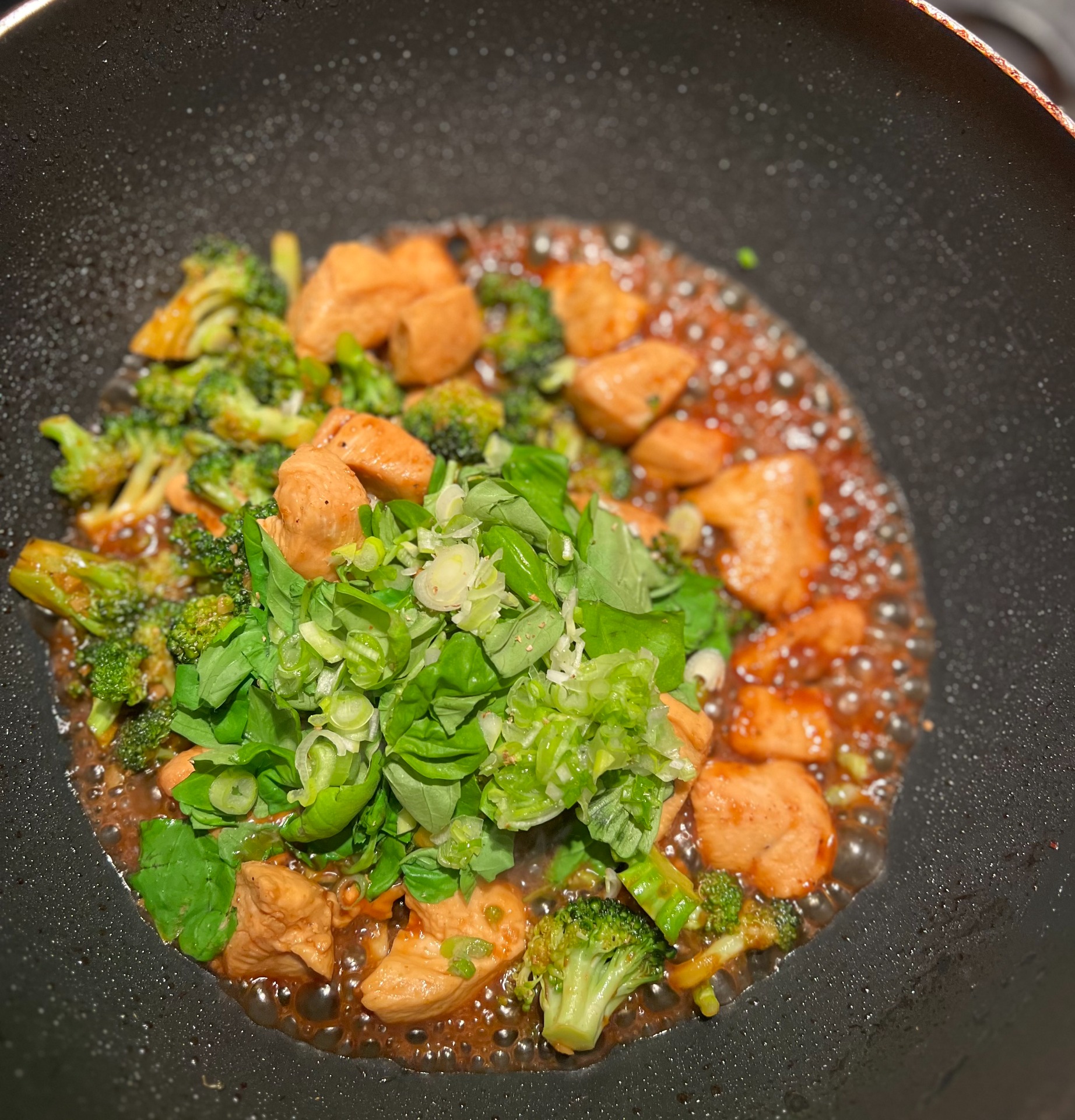 Ajouter les oignons verts, les pois et le basilic et laisser mijoter encore un peu