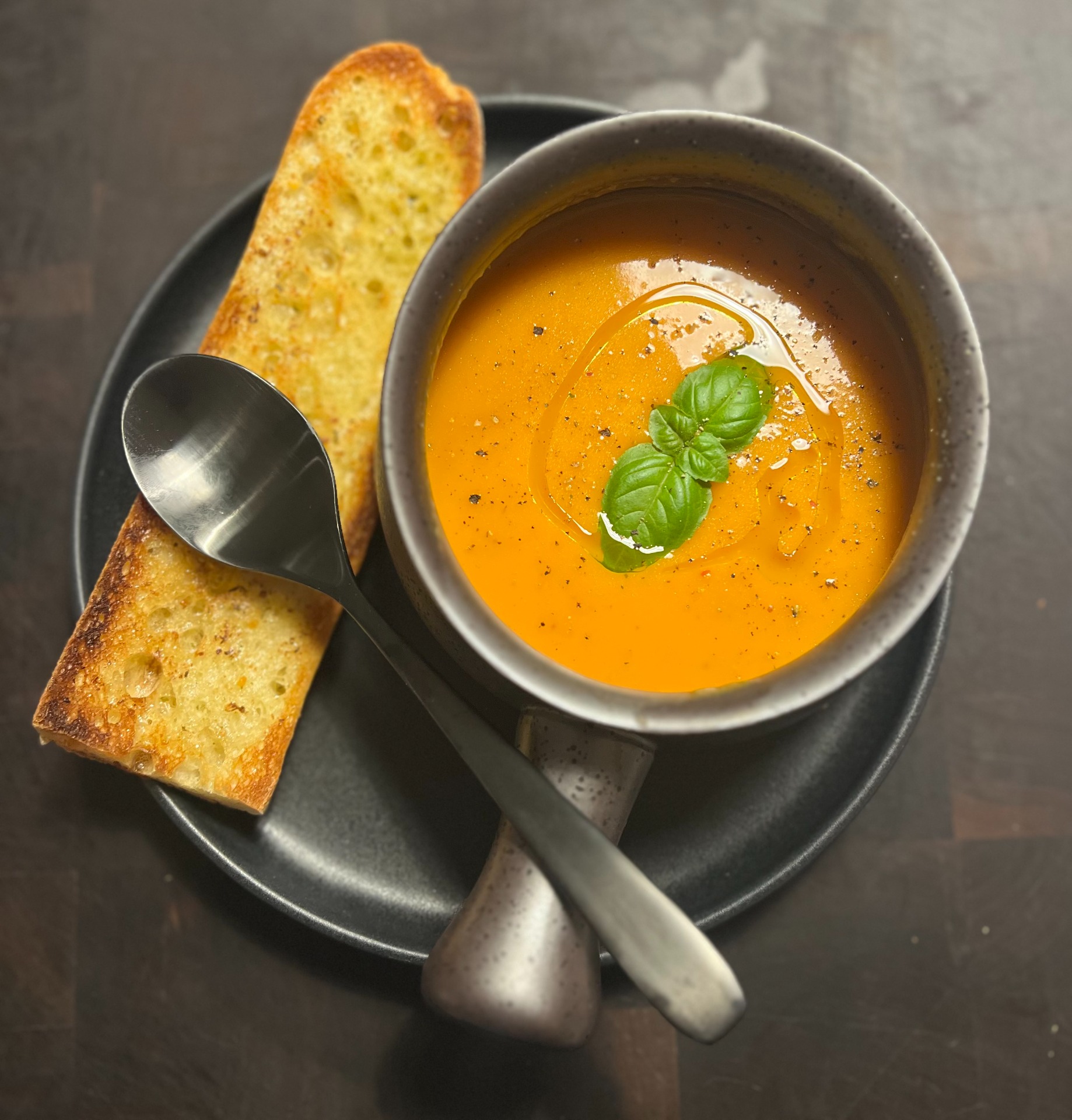 Potage avec un pain à l'ail grillé et son filet d'huile d'olive, mariage parfait