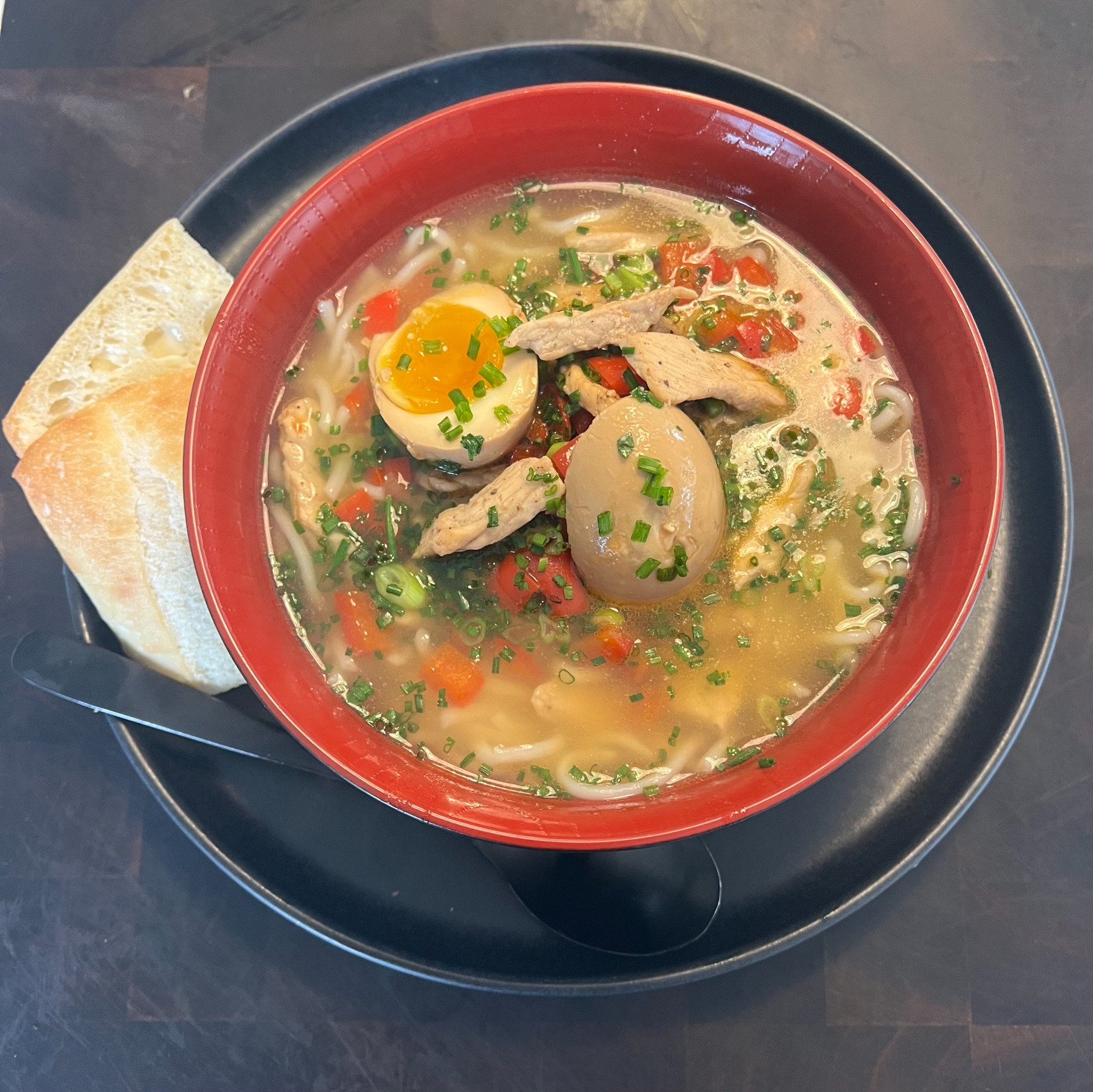 Remen au porc avec des oignons vert et des morceaux de piment rouge dans un petit bouillon de poulet